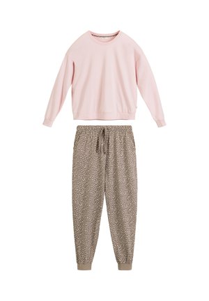 Jasnoróżowa bluza na długi rękaw w połączeniu z beżowymi spodniami dresowymi z nadrukiem w cętki lamparta, wyposażonymi w ściągacze przy kostkach i sznurek w talii.