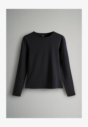 Pikkade varrukatega must särk, mis on valmistatud siledast puuvillakangast, millel on ümmargune kaelus ja otseküte, millel on hemmi külgedel kerged lõhikuid.