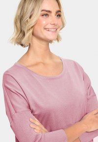 Hellrosa Pullover mit rundem Ausschnitt, gerippten Bündchen und glatter Textur, bietet einen lässigen Schnitt und subtilen Glanz.