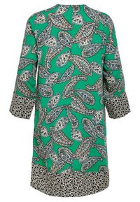 Grön klänning med ett paisleymönster och svarta och vita detaljer vid muddar och fåll, tillverkad av ett mjukt tyg med avslappnad passform.