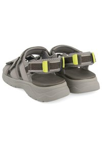 Sandalias grises con correas ajustables, que cuentan con una suela gris acolchada y acentos en verde fluorescente. Diseñadas para la comodidad y el soporte.