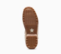 Suela de goma marrón con un patrón texturizado, que presenta un acento de estrella blanca y la letra "CONVERSE" cerca del talón.