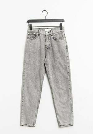 Jeans en denim gris clair taille haute avec bouton et fermeture éclair à l'avant, cinq poches, suspendus sur un cintre noir contre un fond blanc.