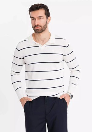 Witte langemouwen polo met navy horizontale strepen, met een kraag en een aansluitend ontwerp, gecombineerd met donkere broeken.