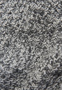 Grau-weiß gestrickter Stoff mit einem strukturierten, welligen Muster, das dickes Garn und ein weiches, warmes Erscheinungsbild zeigt.