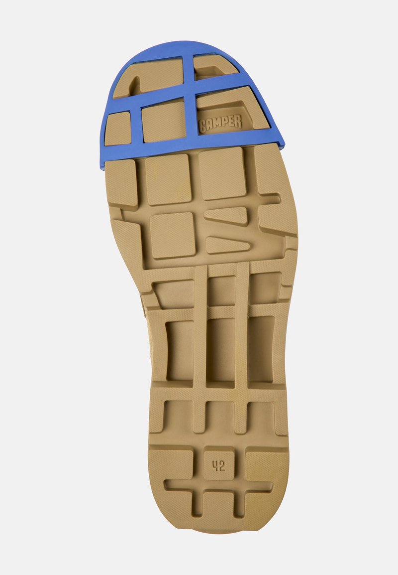 Suola in gomma con base beige e sovrapposizione a rete blu. Superficie testurizzata con pattern moldati per la trazione. Taglia indicata come 42.