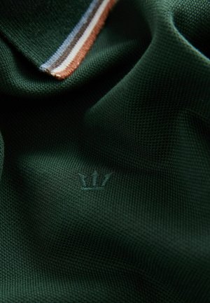 Grøn polo shirt med et struktureret stof, der har en stribet krave i blå, brun og hvid, samt et lille krone logo broderet.