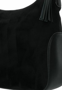 Borsa a mano in suede nera con un accento in pelle liscia, forma rotonda e frange decorative. La texture è morbida con una finitura opaca.