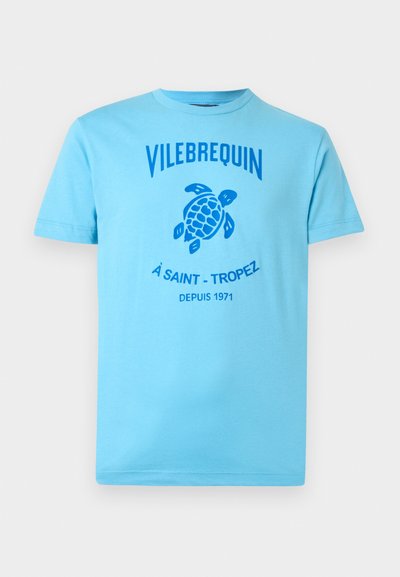 Light blue t-shirt in cotton with a crew neck. Features a blue turtle graphic and "Vilebrequin" text across the chest. Simple, casual design.