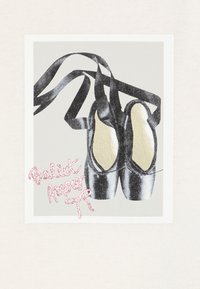 Crne baletne cipela sa satenskim završetkom, bež unutrašnjošću i crnim trakama. Pozadina sadrži sivi panel i ružičasti natpis "Ballet Amour".