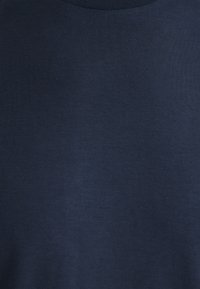 Marineblaue Baumwolltextilie mit einer glatten Oberfläche und geripptem Rundhalsausschnitt. Einheitliche Farbe ohne Muster oder auffällige Hardware. Einfaches Design.