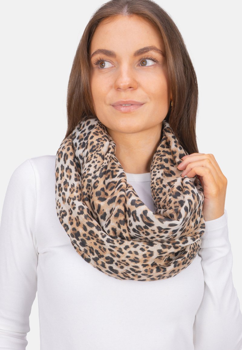 Écharpe à motif léopard en tissu doux, présentant des nuances de marron et de crème. Design en boucle avec une texture visible et des motifs de taches variés.