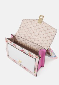 Kabelka s květinovým vzorem, růžovým akcentem, bílým předním panelem a zlatými detaily. Interiér má strukturovaný design s kapsou na zip.