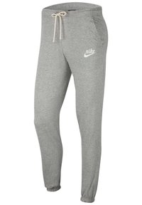 Šedé tepláky z měkké bavlněné směsi s elastickým pasem se stahovací šňůrkou, elastickými manžetami a bílým logem Nike na levém stehně.