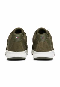Zapatillas de ante verde y malla con suelas blancas. Presentan un logo en el talón y un diseño texturizado. Cierre con cordones para un ajuste seguro.