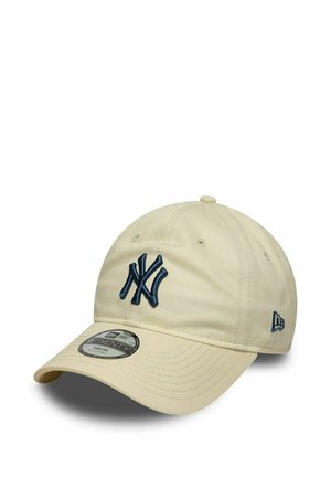 Beżowa czapka baseballowa z ciemnoniebieskim logo New York Yankees i logo New Era, zakrzywionym daszkiem i regulowanym paskiem z tyłu.