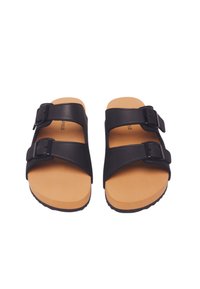 Två svarta sandaler med justerbara remmar, med en slät läderyta och bruna gummisulor med texturerat grepp.