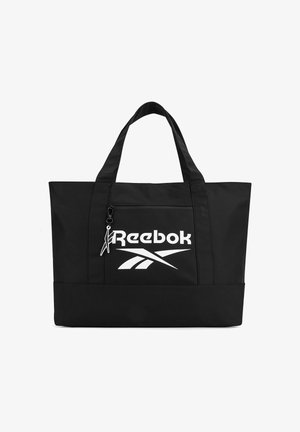Czarna torba Reebok na ramię z dwoma uchwytami, przednia kieszeń na zamek z białym logo oraz suwakiem w kształcie stylizowanej postaci.