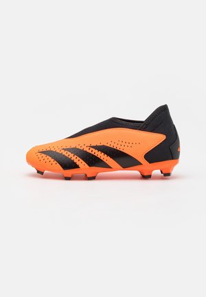 Botín de fútbol naranja y negro con diseño elegante, parte superior texturizada con perforaciones y acentos de rayas negras en el lado.