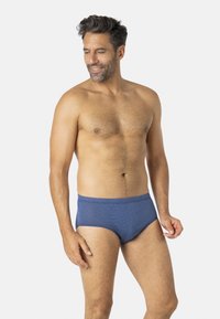 Slip de bain bleu marine avec un motif texturé, une coupe taille moyenne et une ceinture élastique pour un maintien sûr.