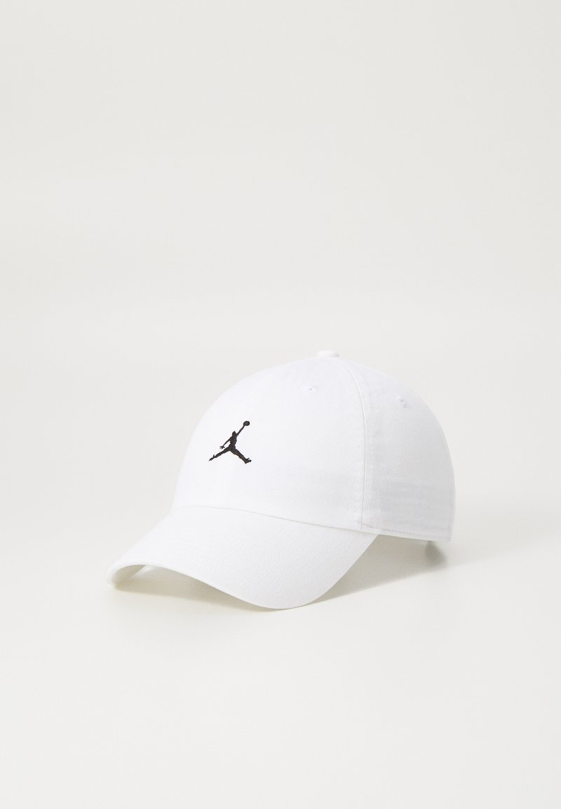 Cască de baseball albă din bumbac, cu o vizieră curbată. Prezintă un logo Jumpman negru brodat pe față pentru o marcă distinctivă.