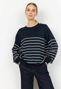 Navy blue sweatshirt with white horizontal stripes, relaxed fit, round neckline, and ribbed cuffs, paired with dark denim pants.