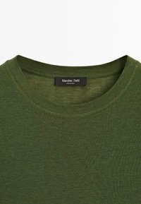 T-shirt in cotone verde con colletto a girocollo, caratterizzato da un'etichetta Massimo Dutti all'interno. La texture appare liscia con un leggero effetto mélange.