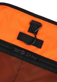 Černý a oranžový zipový pouzdro s texturovanou síťovinou, vybavené černým suchým zipem a akcentem ve tvaru háčku.