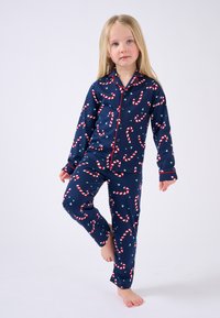 Conjunto de pijama de algodón en color azul marino con un patrón de bastones de caramelo en franjas rojas y blancas. Con un distintivo ribete rojo en el cuello y los puños.