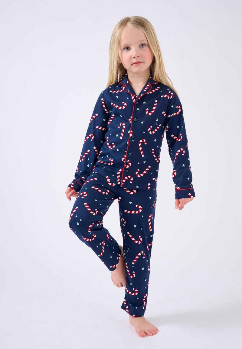 Conjunto de pijama de algodón en color azul marino con un patrón de bastones de caramelo en franjas rojas y blancas. Con un distintivo ribete rojo en el cuello y los puños.