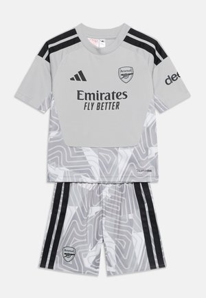 Φανέλα της ομάδας Arsenal σε γκρι με μαύρες ρίγες Adidas, το λογότυπο Emirates Fly Better και διακριτικό αφηρημένο σχέδιο στη φανέλα και το σορτς.