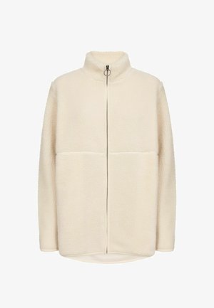 Kerman fleece-takki korkealla kauluksella, etuvetoketjulla ja kahdella suurella vaakasuoralla taskulla. Pehmeä rakenne hieman ylisuurella mitoituksella.