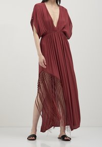 Maroon maxi dress with a deep V-neck, short batwing sleeves, and a fringed hem featuring decorative beads. Smooth, lightweight fabric.