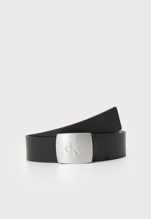 Juodas odinis diržas su stačiakampiu sidabro spalvos metalo sagtimi, ant kurios išgraviruotas "CK" logotipas. Lygi tekstūra ir elegantiškas dizainas.