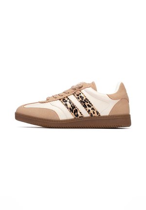 Zapatilla beige y blanca con suela marrón y rayas de estampado de leopardo en el costado, vista desde la parte trasera exterior.
