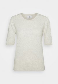 Haut court à manches courtes couleur crème avec un col rond, présentant un motif texturé et un détail en forme de losange en bas.