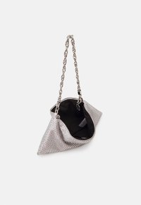 Sac à main triangulaire argenté avec une bandoulière en chaîne, fermeture éclair ouverte montrant une doublure intérieure noire.