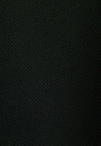 Surface noire texturée avec de petites boucles étroitement tissées créant un motif de tissu uniforme et dense.