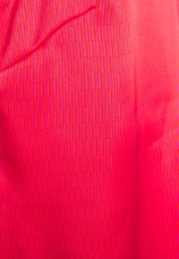 Jasnoróżowa tkanina o fakturowanym wzorze pionowych pasków, charakteryzująca się gładką powierzchnią i delikatnym połyskiem.