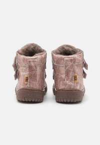 Bottes basses en cuir rose avec finition texturée, semelles en caoutchouc marron et accents gris. Dotées de deux sangles latérales pour la fermeture.