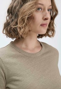 Khaki T-Shirt mit kurzen Ärmeln, klassischem Rundhalsausschnitt, weichem Baumwolltextil und subtilen Variationen im Stoffton.