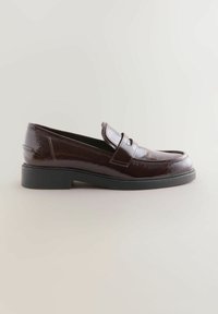 Mocassini in pelle verniciata bordeaux con punta arrotondata, upper in pelle, dettagli cuciti e tacco in gomma basso. Finitura liscia e lucida.