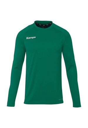 T-shirt de sport vert à manches longues avec col rond ; fabriqué en tissu lisse ; présente le logo blanc 'Kempa' sur la partie gauche de la poitrine.