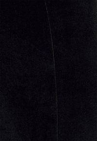 Tecido de veludo preto com uma textura suave, apresentando um brilho subtil. A superfície exibe uma cor uniforme com variação ou padrão mínimo.