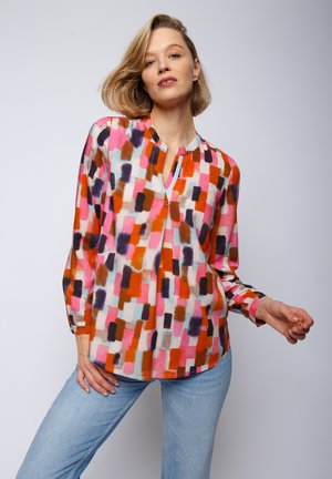 Multikleurige blouse met een geometrisch patroon in roze, rood, oranje en blauw, met een v-hals en lange mouwen. Lichtgewicht stof.