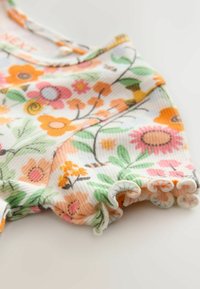 Lillelillelise lillemustriga romper pehmest kangast, millel on erksad oranžid, roosad ja rohelised lilled. Rikkalikud servad lisavad tekstuuri ja detaile.