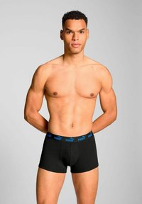 Black boxer shorts with a blue elastic waistband featuring the Puma logo. The fabric appears smooth with a fitted design.