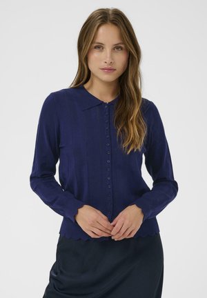 Marineblauer Cardigan mit kragenförmigem Ausschnitt, gerippter Textur, langen Ärmeln und gewelltem Saum. Er verfügt über eine Knopfleiste und vertikale Streifen.