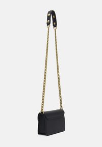 Bolso de mano de imitación cuero negro con cierre de solapa, que presenta una correa de cadena en tono dorado y acentos de cuero negro. Textura suave, diseño compacto.