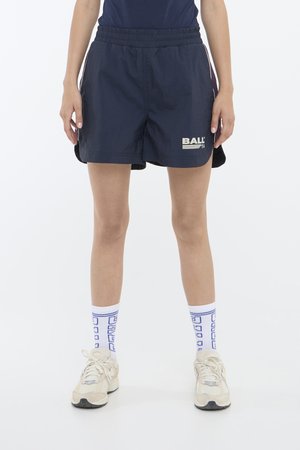 Marine sportshorts met een elastische tailleband, voorzien van een witte "BALL" logo. Gecombineerd met blauw-witte gestreepte crew-sokken en beige schoenen.